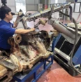 Technicians refurbishing the eroded outlet nozzle of a recycled gas compressor housing by pulsed laser beam welding
