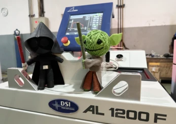Stormtrooper and Baby Yoda figures posed on a DSI Laser AL 1200F pulse laser welding machine