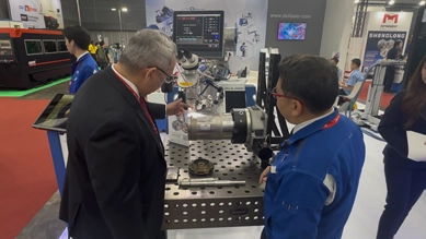Visitors watching a pulse laser welding demonstration at the DSI exhibition booth