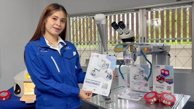 DSI staff member holding the Pulse Laser Welding Machines catalog next to a laser welding machine